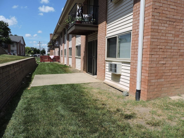 703 E Fullerton Ave Unit 1-110, Glendale Heights, IL 60139 - view of side of home with a balcony, a lawn, and brick siding