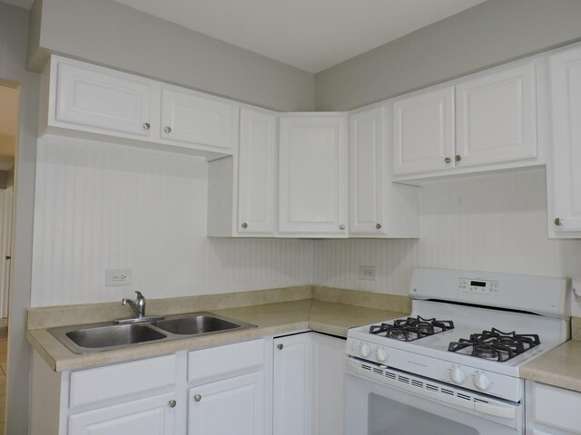 703 E Fullerton Ave Unit 1-110, Glendale Heights, IL 60139 - kitchen featuring white gas stove, light countertops, and white cabinetry
