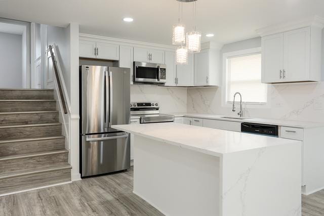 615 E 101st Pl, Chicago, IL 60628 - kitchen with appliances with stainless steel finishes, a sink, a kitchen island, white cabinets, and recessed lighting