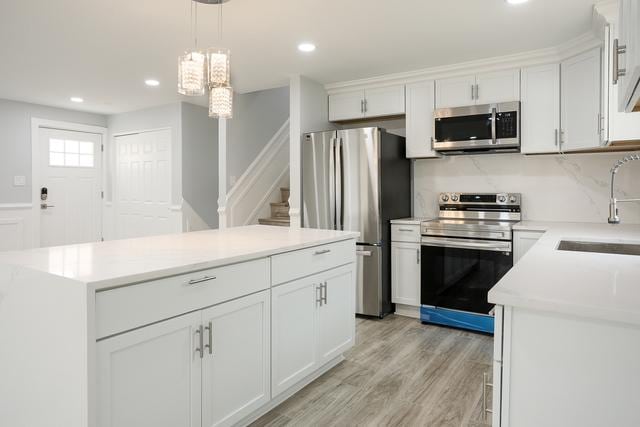 615 E 101st Pl, Chicago, IL 60628 - kitchen featuring stainless steel appliances, a sink, a center island, white cabinets, and recessed lighting