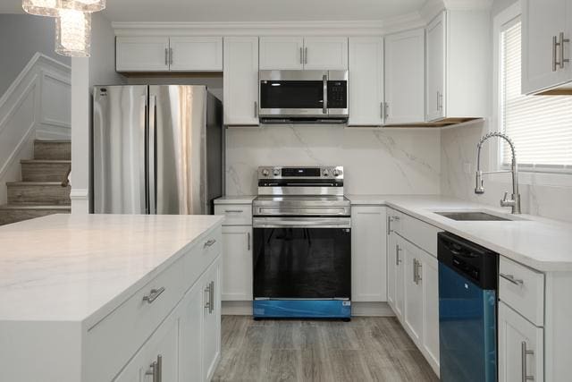 615 E 101st Pl, Chicago, IL 60628 - kitchen with stainless steel appliances, a sink, healthy amount of natural light, and light wood-style floors