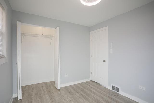 615 E 101st Pl, Chicago, IL 60628 - unfurnished bedroom featuring light wood-type flooring, a closet, and baseboards