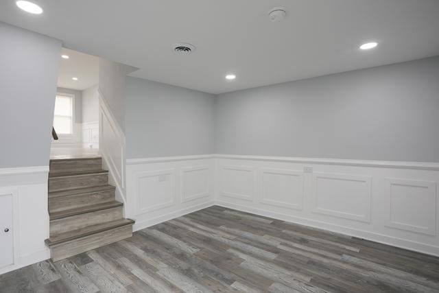 615 E 101st Pl, Chicago, IL 60628 - unfurnished room featuring a decorative wall, wainscoting, dark wood-style flooring, recessed lighting, and stairway