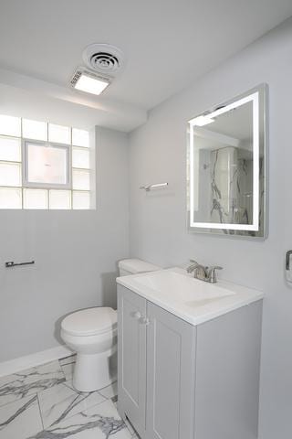 615 E 101st Pl, Chicago, IL 60628 - full bathroom featuring toilet, vanity, marble finish floors, and baseboards