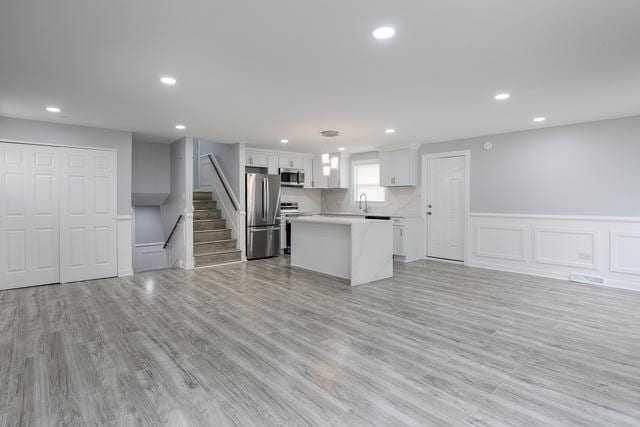 615 E 101st Pl, Chicago, IL 60628 - kitchen featuring appliances with stainless steel finishes, open floor plan, a kitchen island, white cabinetry, and recessed lighting