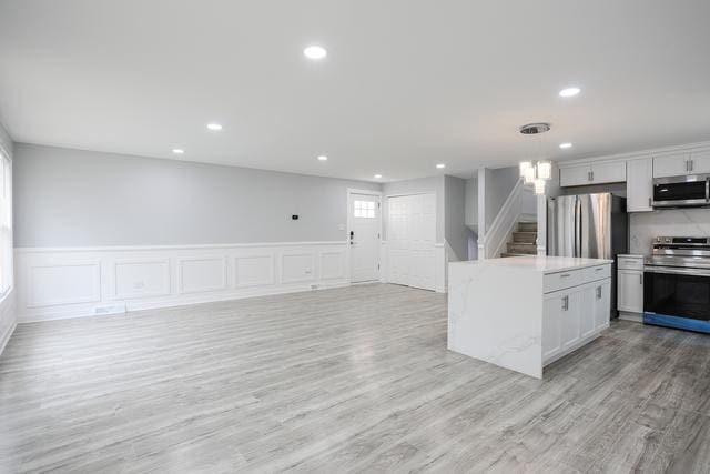 615 E 101st Pl, Chicago, IL 60628 - kitchen featuring appliances with stainless steel finishes, recessed lighting, light wood-style flooring, open floor plan, and hanging light fixtures