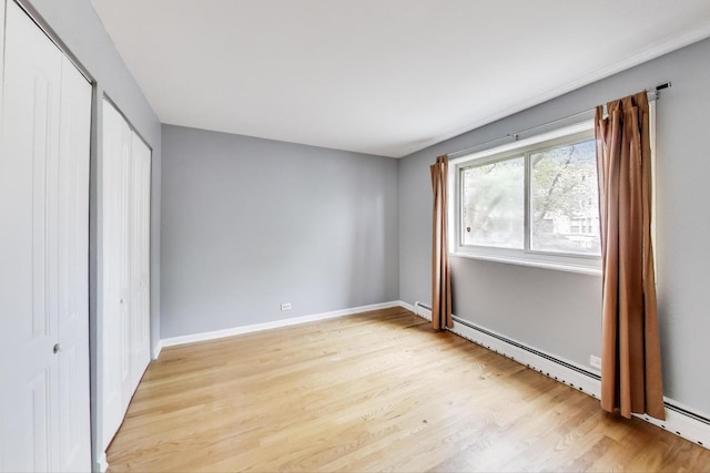 1415 W Lunt Ave Unit 203, Chicago, IL 60626 - unfurnished bedroom with light wood-type flooring, baseboards, and baseboard heating