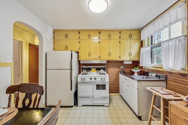 10752 S Washtenaw Ave, Chicago, IL 60655 - kitchen with white appliances, a sink, arched walkways, under cabinet range hood, and light floors