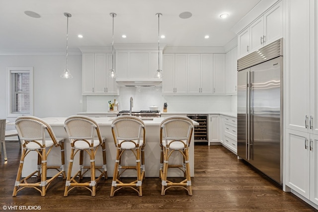 843 W Buckingham Pl Unit 1W, Chicago, IL 60657 - kitchen with stainless steel built in refrigerator, beverage cooler, light countertops, an island with sink, and dark wood finished floors
