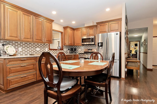 611 Filly Ln, Grayslake, IL 60030 - kitchen featuring stainless steel appliances, decorative backsplash, dark wood-style flooring, brown cabinetry, and light stone counters