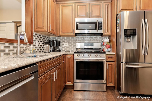611 Filly Ln, Grayslake, IL 60030 - kitchen with appliances with stainless steel finishes, backsplash, light stone counters, dark wood-style floors, and brown cabinetry