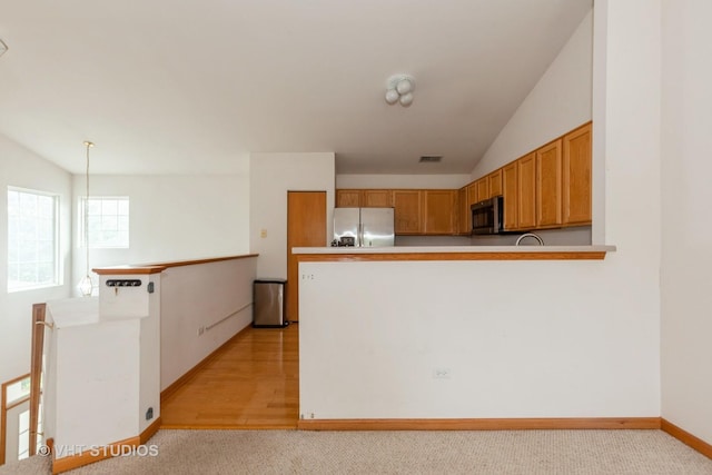 24149 W Pear Tree Cir Unit A, Plainfield, IL 60585 - kitchen with stainless steel appliances, a peninsula, lofted ceiling, light countertops, and light carpet
