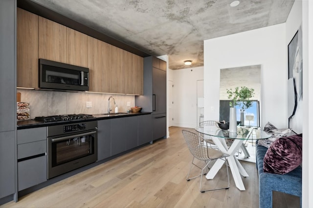 234 W Polk St Unit 2907, Chicago, IL 60607 - kitchen featuring oven, dark countertops, modern cabinets, and light wood-style flooring