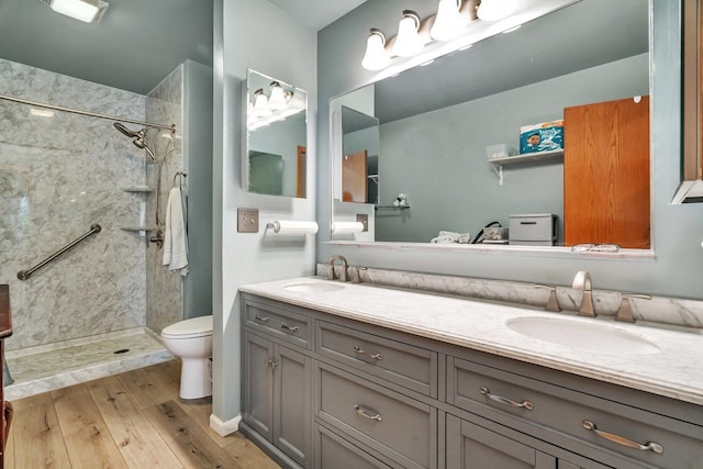 1072 Ronald Dr, Joliet, IL 60435 - bathroom featuring double vanity, tiled shower, wood finished floors, and toilet