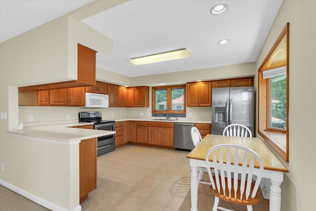309 E Mchenry St, Urbana, IL 61801 - kitchen featuring stainless steel appliances, light countertops, plenty of natural light, brown cabinets, and recessed lighting