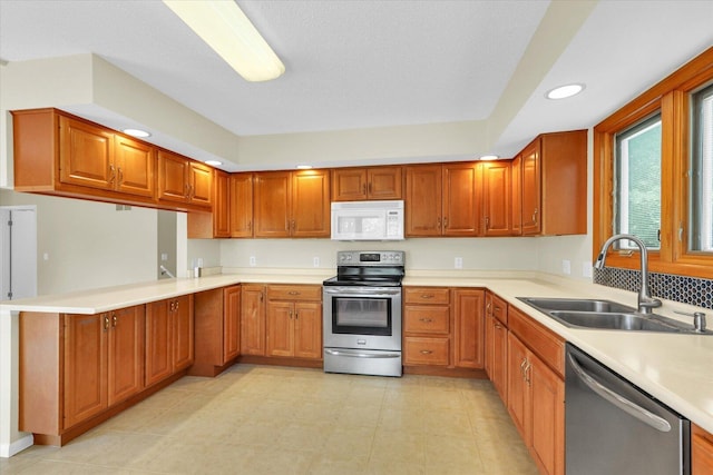 309 E Mchenry St, Urbana, IL 61801 - kitchen with appliances with stainless steel finishes, light countertops, brown cabinets, and recessed lighting
