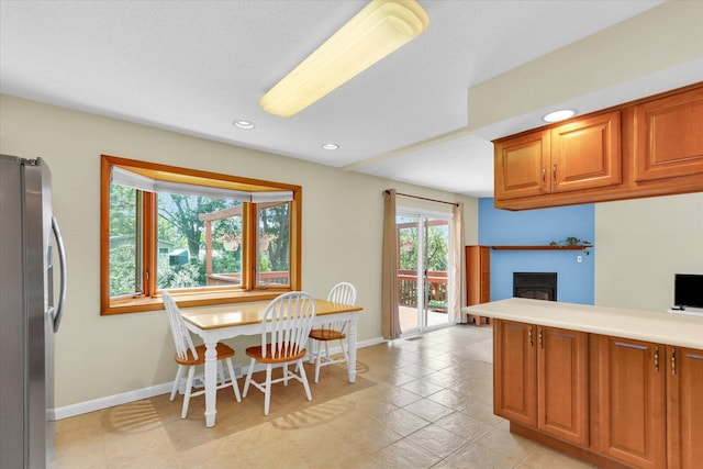 309 E Mchenry St, Urbana, IL 61801 - kitchen featuring freestanding refrigerator, a fireplace, brown cabinets, recessed lighting, and light countertops