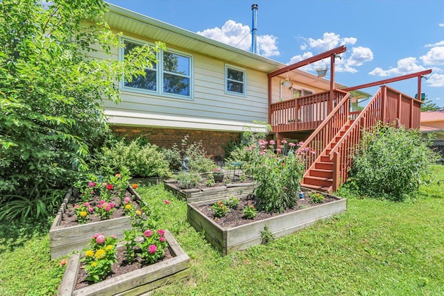 309 E Mchenry St, Urbana, IL 61801 - rear view of house with a garden, stairs, a wooden deck, a lawn, and brick siding