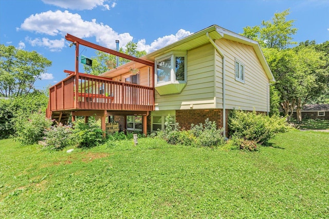 309 E Mchenry St, Urbana, IL 61801 - back of property featuring a wooden deck, a lawn, and brick siding