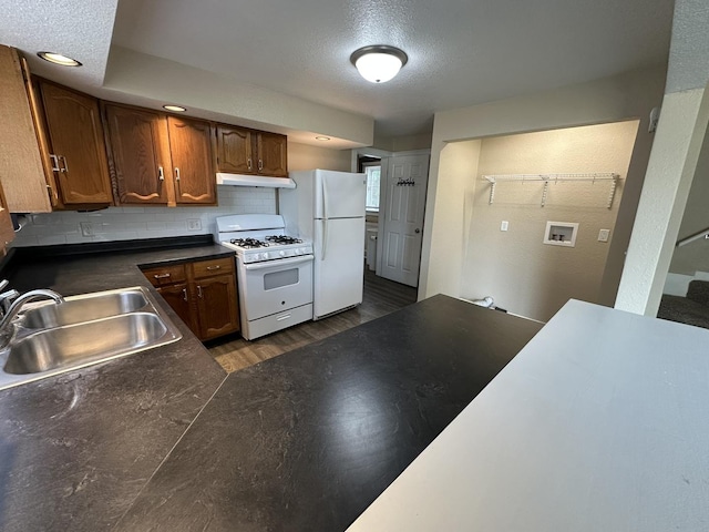 1109 S Locust Ave, Freeport, IL 61032 - kitchen featuring white appliances, a sink, under cabinet range hood, dark wood-style flooring, and dark countertops