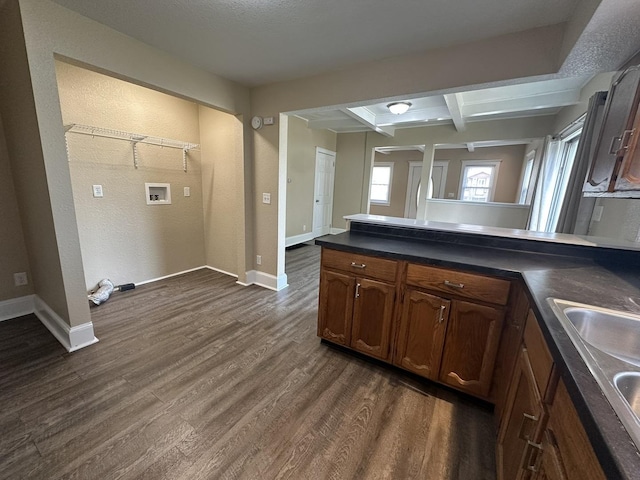 1109 S Locust Ave, Freeport, IL 61032 - kitchen featuring a peninsula, dark wood-type flooring, dark countertops, a sink, and baseboards