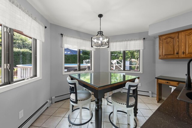 5760 Woodward Ave, Downers Grove, IL 60516 - dining area with a baseboard heating unit, healthy amount of natural light, light tile patterned floors, and a chandelier