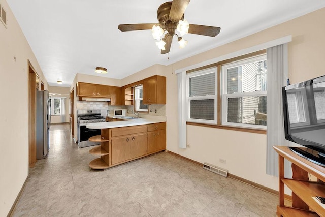 5438 S Hamlin Ave, Chicago, IL 60632 - kitchen with stainless steel appliances, open shelves, a peninsula, light countertops, and brown cabinetry