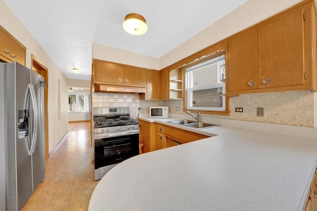 5438 S Hamlin Ave, Chicago, IL 60632 - kitchen with stainless steel appliances, a sink, light countertops, under cabinet range hood, and decorative backsplash