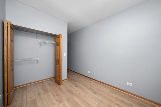 6528 S University Ave Unit 3N, Chicago, IL 60615 - unfurnished bedroom with light wood-style floors, a closet, and baseboards