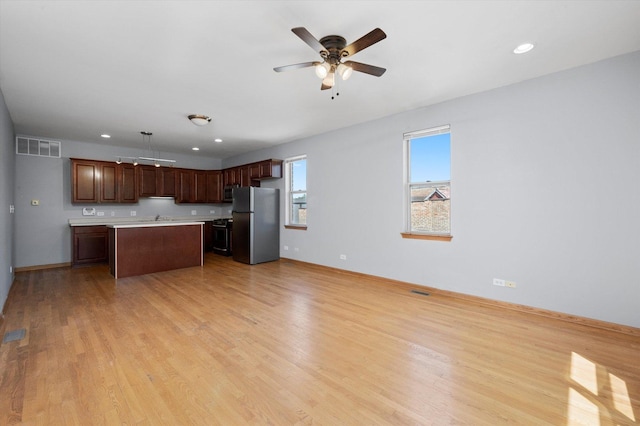 6528 S University Ave Unit 3N, Chicago, IL 60615 - kitchen featuring stainless steel appliances, light countertops, ceiling fan, a center island, and light wood-type flooring