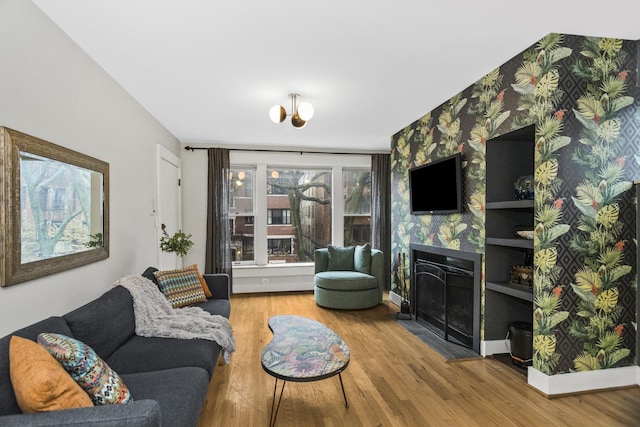 913 Michigan Ave Unit 3, Evanston, IL 60202 - living area featuring a fireplace, wood finished floors, wallpapered walls, and a chandelier