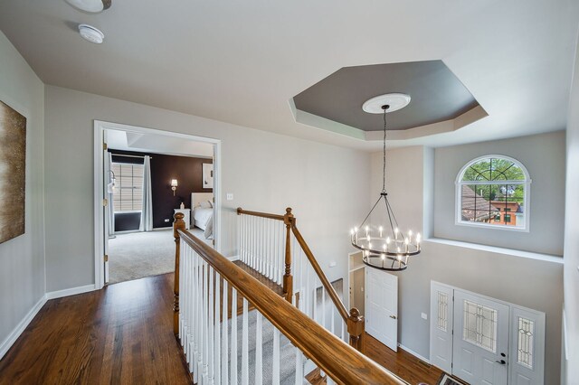 1N183 Stacy Ct, Glen Ellyn, IL 60137 - hall featuring an upstairs landing, dark wood-type flooring, a chandelier, and a tray ceiling
