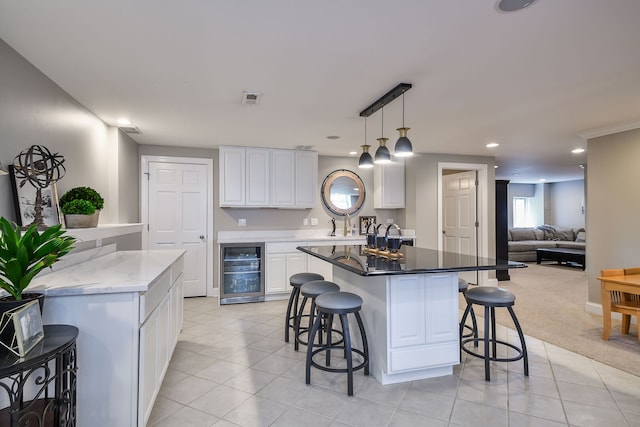 1N183 Stacy Ct, Glen Ellyn, IL 60137 - kitchen featuring beverage cooler, a kitchen island, a breakfast bar, white cabinetry, and light tile patterned floors
