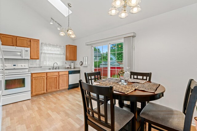 1239 Spring Creek Rd, Elgin, IL 60120 - dining area featuring a chandelier, a skylight, lofted ceiling, light wood-style floors, and track lighting