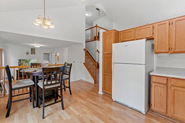 1239 Spring Creek Rd, Elgin, IL 60120 - dining area with light wood-style flooring, high vaulted ceiling, a chandelier, and stairway