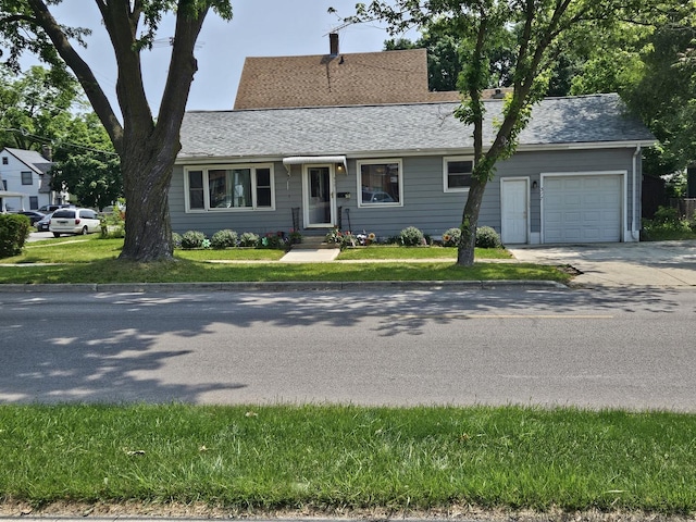 317 N Highland Ave, Aurora, IL 60506 - view of front facade featuring driveway, an attached garage, a front yard, and a shingled roof