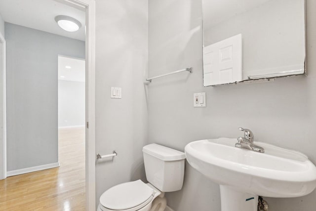 1819 W Touhy Ave Unit 2, Chicago, IL 60626 - half bathroom with toilet, wood finished floors, baseboards, and a sink