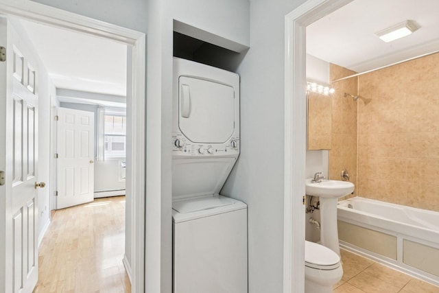 1819 W Touhy Ave Unit 2, Chicago, IL 60626 - laundry area with stacked washing machine and dryer and baseboard heating