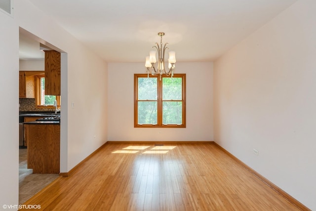 8885 Dryden St, Woodridge, IL 60517 - unfurnished room featuring a chandelier, light wood-style floors, and baseboards