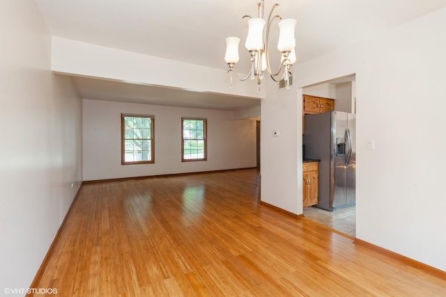 8885 Dryden St, Woodridge, IL 60517 - unfurnished room featuring a chandelier, light wood-type flooring, and baseboards