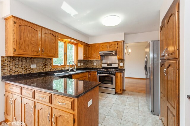 8885 Dryden St, Woodridge, IL 60517 - kitchen with stainless steel appliances, a peninsula, under cabinet range hood, brown cabinetry, and tasteful backsplash