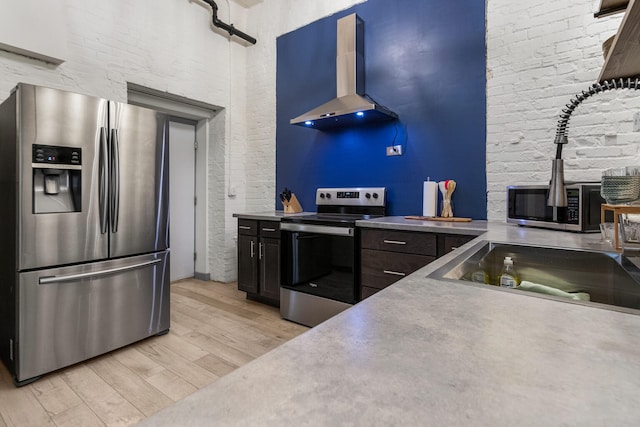 519 N Hickory St Unit 519, Champaign, IL 61820 - kitchen featuring appliances with stainless steel finishes, wall chimney exhaust hood, light wood finished floors, and a high ceiling
