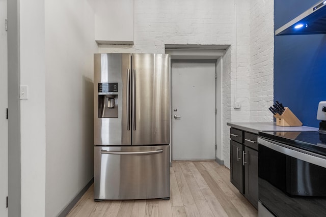 519 N Hickory St Unit 519, Champaign, IL 61820 - kitchen with stainless steel fridge, black range with electric stovetop, light wood-type flooring, brick wall, and ventilation hood