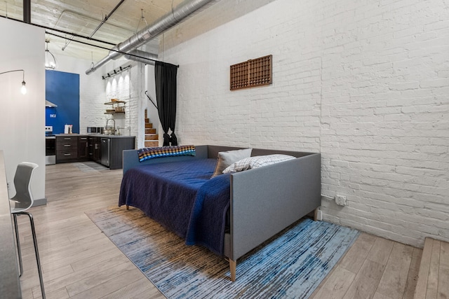 519 N Hickory St Unit 519, Champaign, IL 61820 - living area featuring light wood-type flooring, brick wall, a high ceiling, and stairs