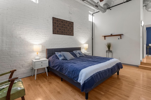 519 N Hickory St Unit 519, Champaign, IL 61820 - bedroom featuring wood finished floors, a towering ceiling, and brick wall