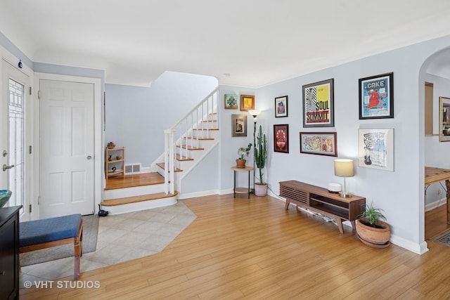6967 W Wolfram St, Chicago, IL 60634 - foyer with arched walkways, wood finished floors, and stairs