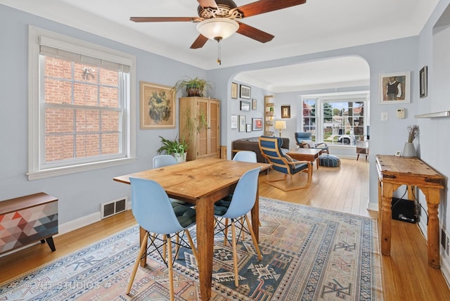 6967 W Wolfram St, Chicago, IL 60634 - dining space featuring arched walkways, ceiling fan, and light wood finished floors