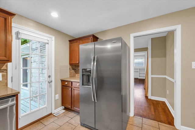 1204 Mayfair Rd, Champaign, IL 61821 - kitchen with stainless steel appliances, decorative backsplash, brown cabinetry, recessed lighting, and light stone countertops