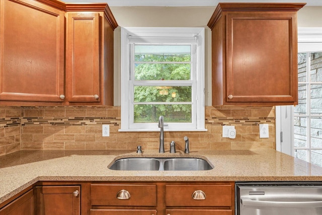 1204 Mayfair Rd, Champaign, IL 61821 - kitchen with stainless steel dishwasher, decorative backsplash, light stone counters, and brown cabinets