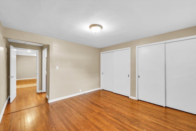 1204 Mayfair Rd, Champaign, IL 61821 - unfurnished bedroom featuring multiple closets and wood finished floors